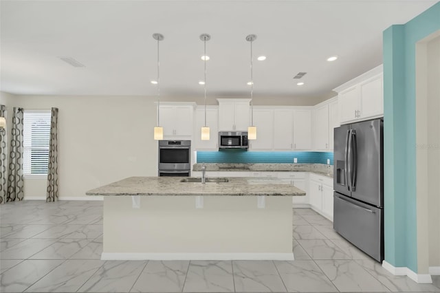 kitchen featuring a breakfast bar area, sink, appliances with stainless steel finishes, and a kitchen island with sink