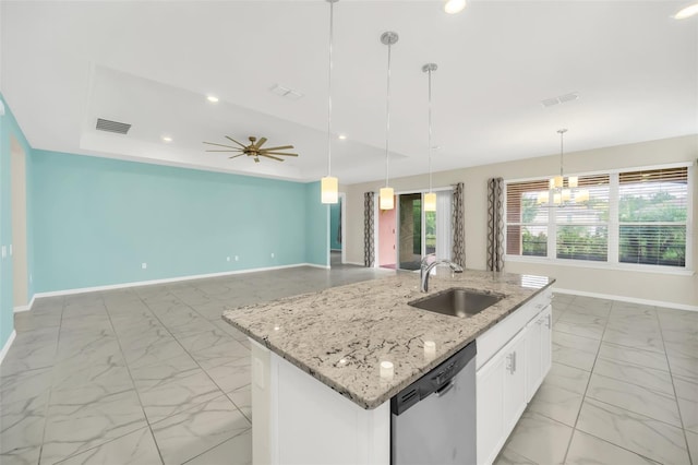 kitchen featuring ceiling fan with notable chandelier, a center island with sink, stainless steel dishwasher, sink, and white cabinetry