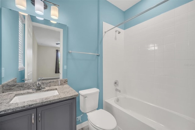 full bathroom featuring tiled shower / bath, vanity, and toilet