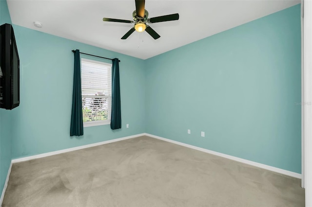 carpeted spare room featuring ceiling fan