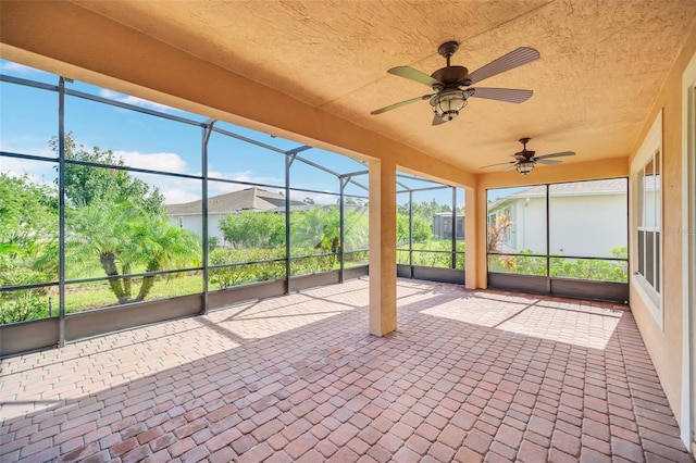 unfurnished sunroom featuring ceiling fan