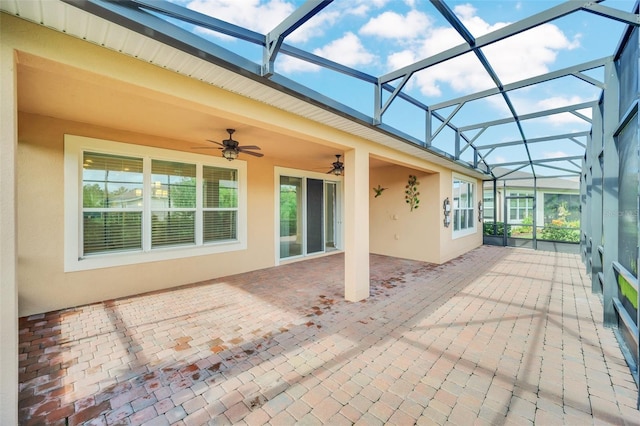 view of patio with glass enclosure and ceiling fan