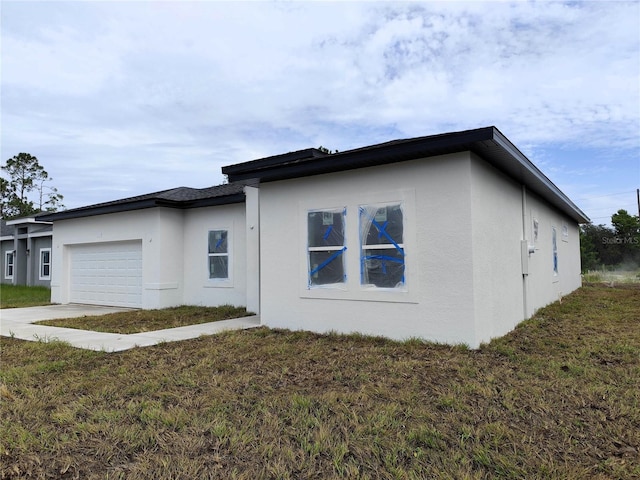 view of side of home with a lawn and a garage