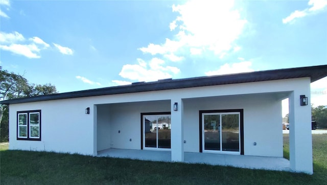 rear view of house with a patio area and a lawn