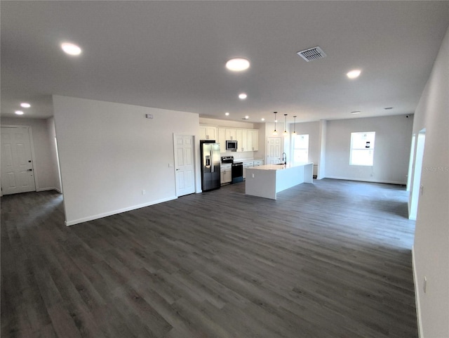 unfurnished living room featuring sink and dark wood-type flooring