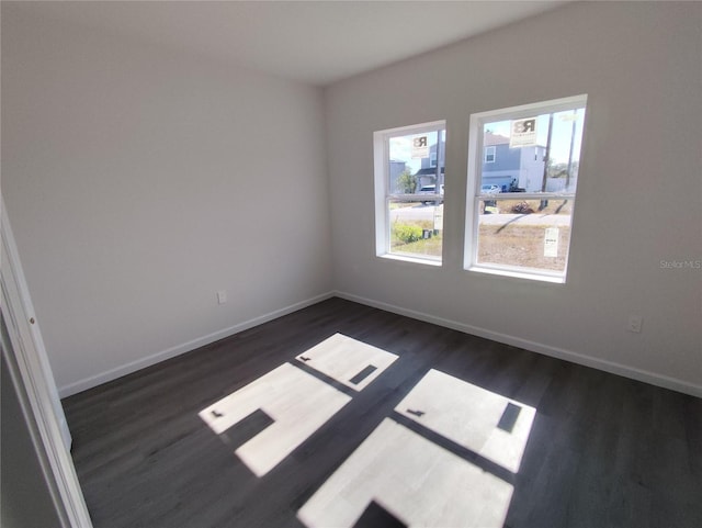 unfurnished room with dark wood-type flooring