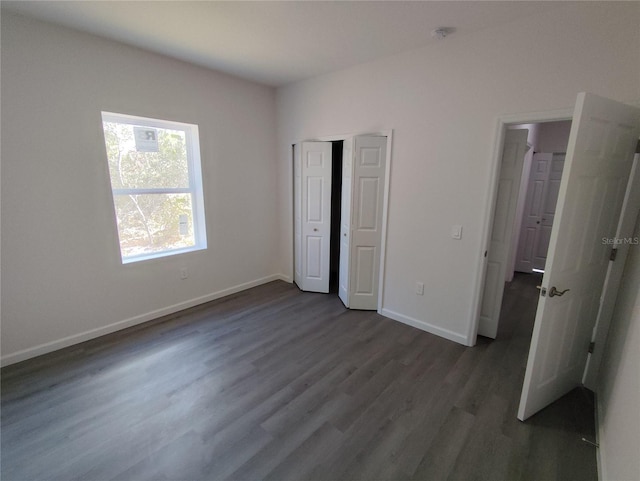 unfurnished bedroom with dark wood-type flooring