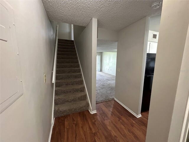 stairway featuring hardwood / wood-style flooring and a textured ceiling