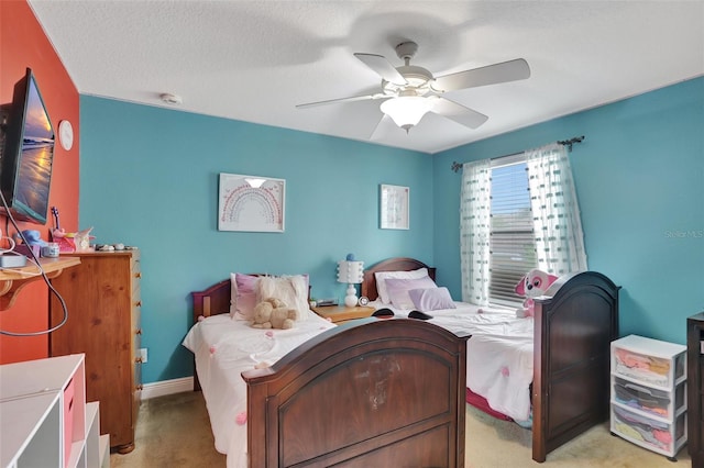 bedroom featuring a textured ceiling, ceiling fan, and light carpet