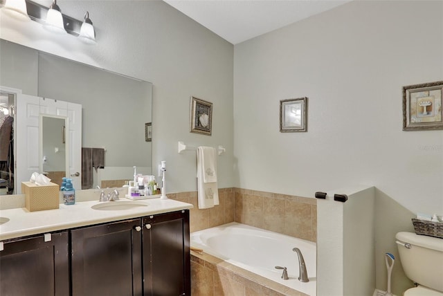 bathroom featuring toilet, tiled bath, and vanity