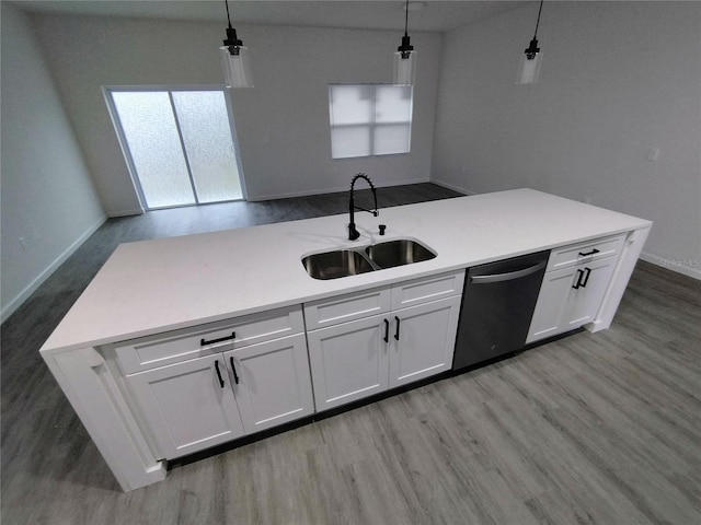 kitchen featuring light hardwood / wood-style flooring, white cabinetry, sink, pendant lighting, and stainless steel dishwasher