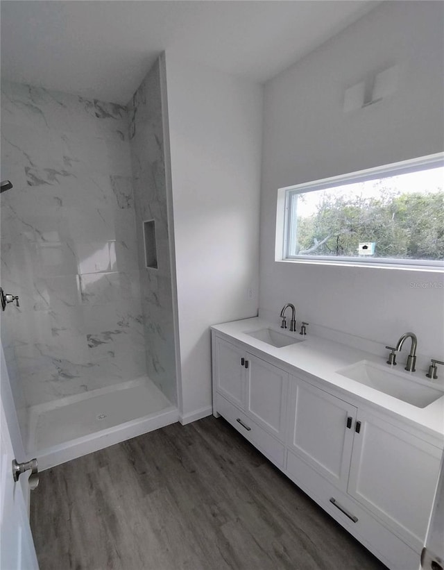 bathroom featuring tiled shower, hardwood / wood-style floors, and vanity