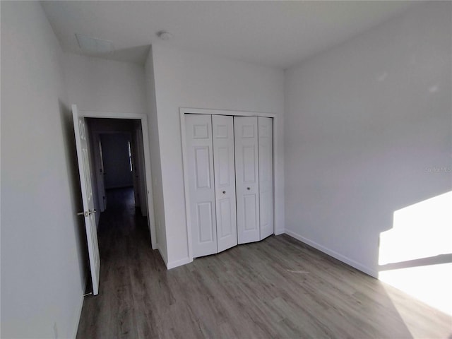 unfurnished bedroom with a closet and hardwood / wood-style floors