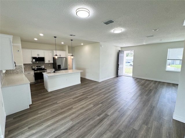 kitchen featuring appliances with stainless steel finishes, dark hardwood / wood-style flooring, white cabinets, a center island, and hanging light fixtures