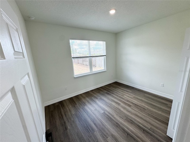 unfurnished room featuring a textured ceiling and dark wood-type flooring