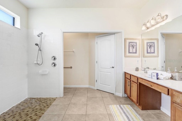 bathroom with vanity, tile patterned flooring, and tiled shower