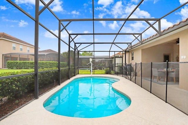 view of swimming pool featuring a lanai, ceiling fan, and a patio area