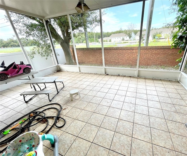 unfurnished sunroom with ceiling fan