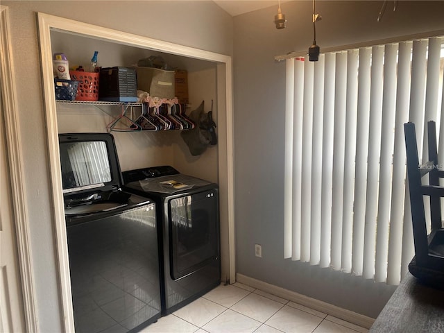 laundry room with washer and clothes dryer and light tile patterned floors