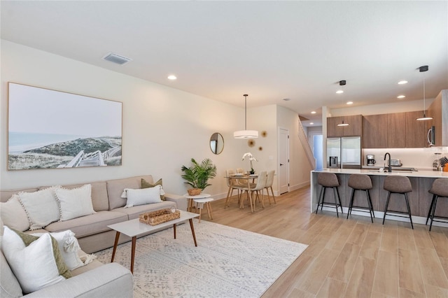 living room featuring sink and light wood-type flooring