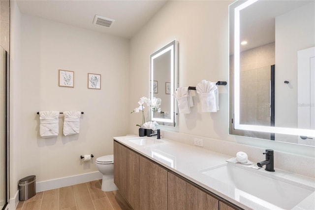 bathroom featuring a shower with shower door, toilet, hardwood / wood-style flooring, and vanity