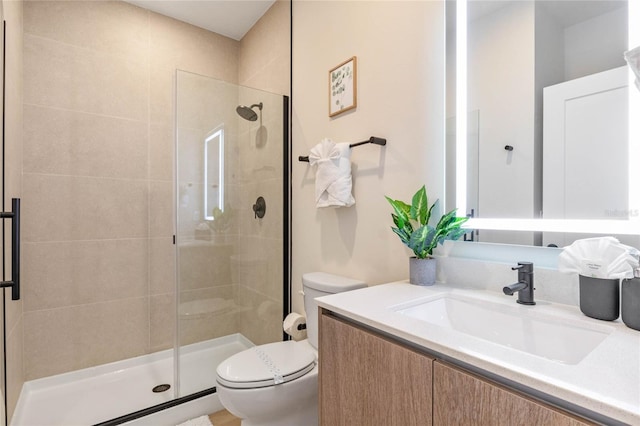 bathroom with vanity, toilet, and a shower with shower door