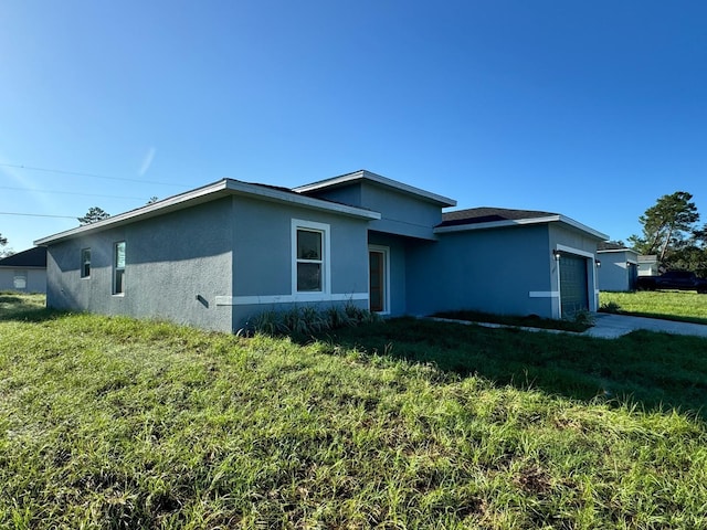 view of front of house with stucco siding, a garage, concrete driveway, and a front lawn