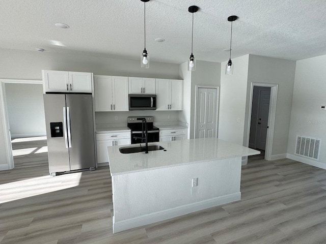 kitchen with white cabinetry, a sink, visible vents, and stainless steel appliances