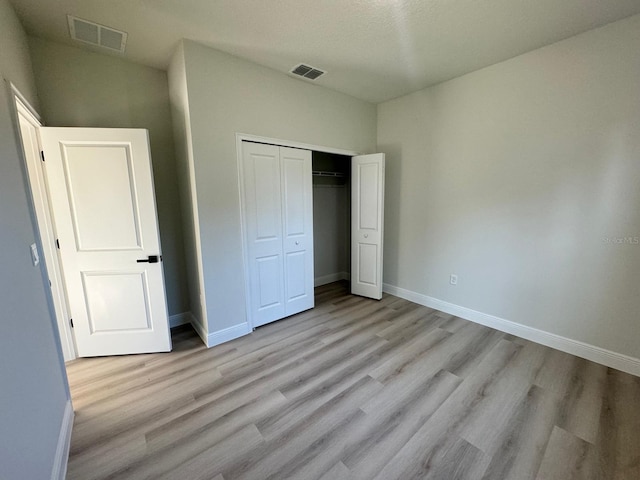 unfurnished bedroom featuring visible vents, baseboards, and light wood finished floors