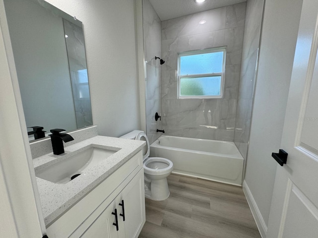 full bathroom with toilet, wood finished floors, baseboards, bathtub / shower combination, and vanity