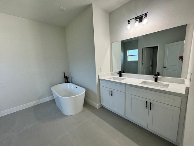 bathroom featuring a sink, baseboards, a soaking tub, and double vanity