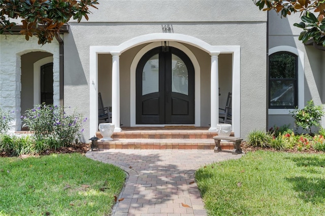 property entrance with french doors and a lawn