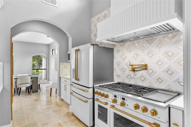 kitchen with white cabinetry, white appliances, premium range hood, and tasteful backsplash