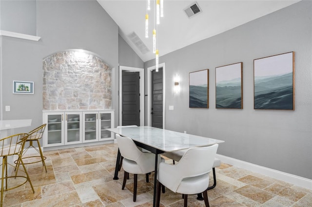 dining area with high vaulted ceiling