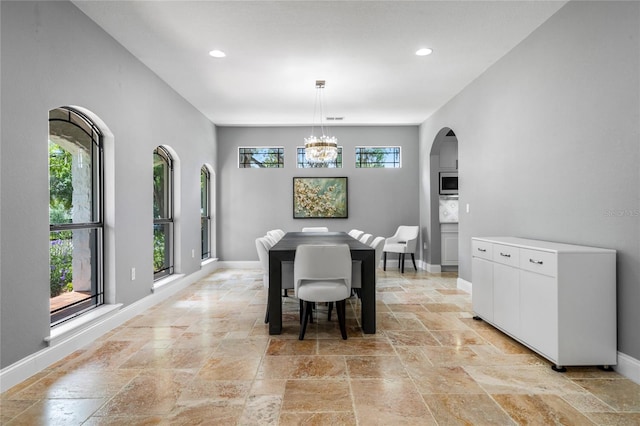 dining area with plenty of natural light and a notable chandelier