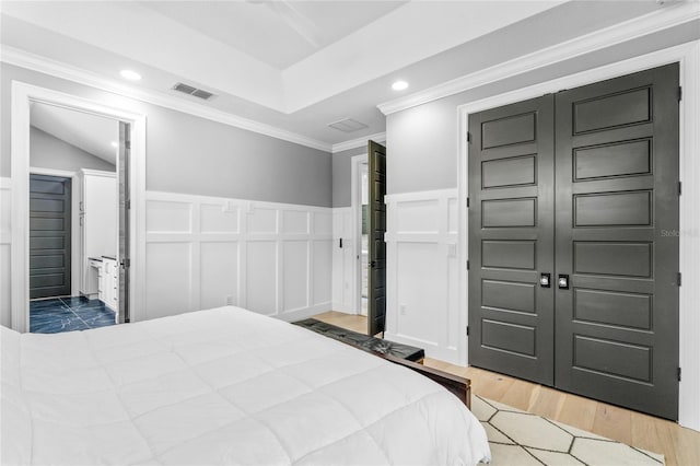 bedroom featuring ornamental molding, light hardwood / wood-style flooring, ceiling fan, a closet, and lofted ceiling