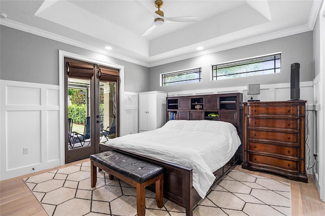 bedroom with a raised ceiling, access to outside, crown molding, ceiling fan, and light wood-type flooring