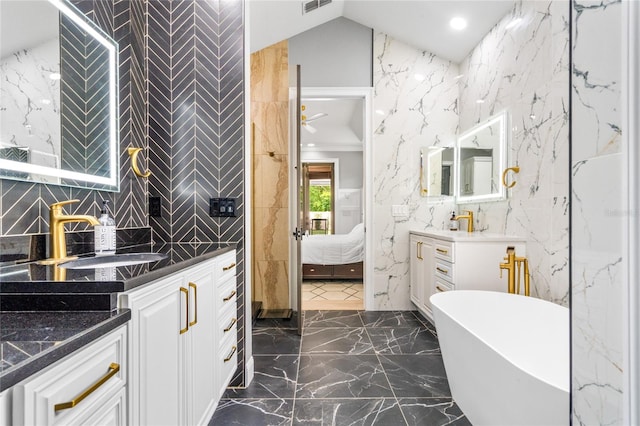 bathroom featuring a bath, vaulted ceiling, and vanity