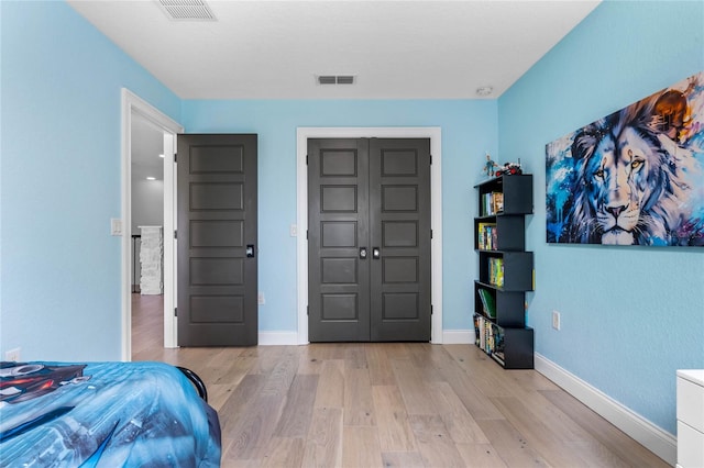 bedroom with light wood-type flooring and a closet