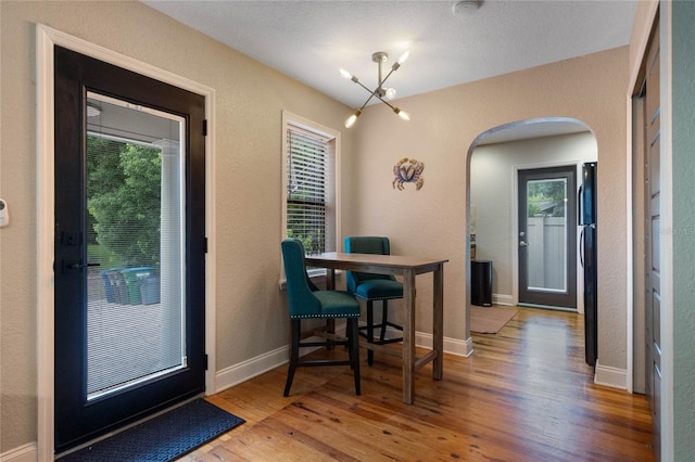 dining space with hardwood / wood-style flooring and a textured ceiling