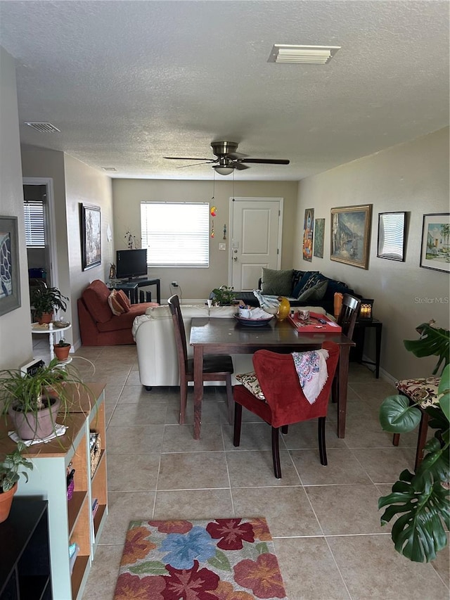 dining space with a textured ceiling, ceiling fan, and light tile patterned floors