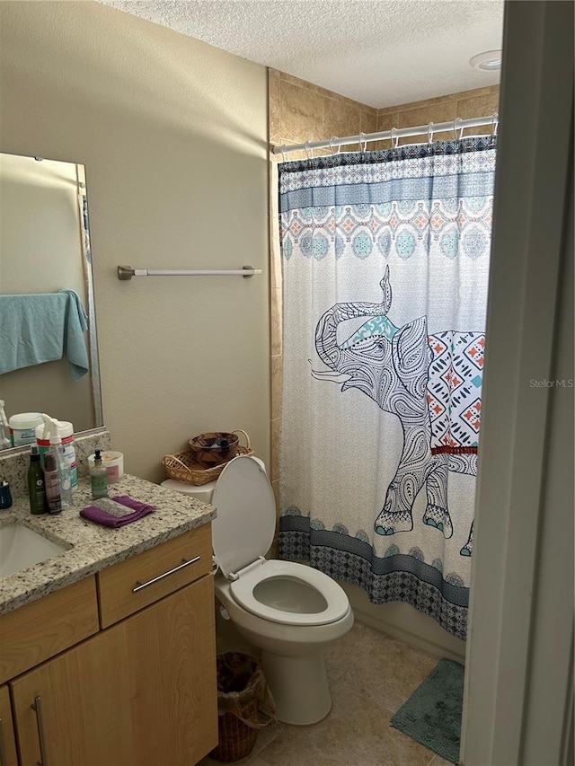 bathroom with a textured ceiling, vanity, and toilet