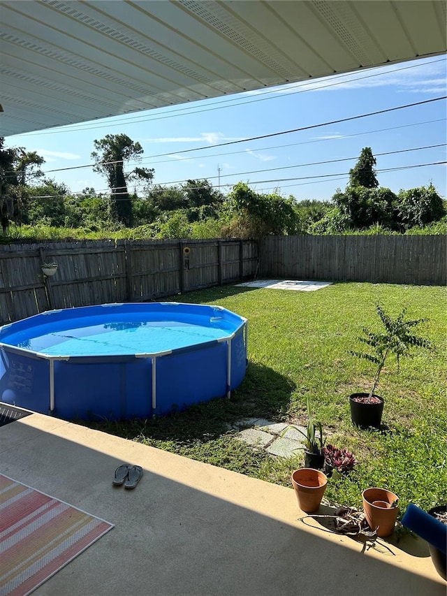 view of swimming pool with a yard