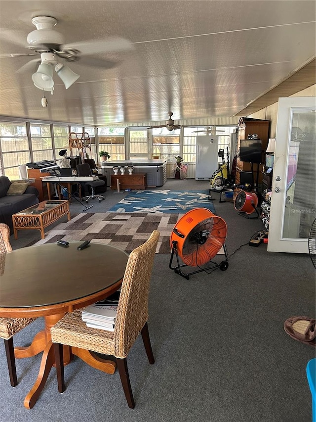 carpeted dining room with ceiling fan