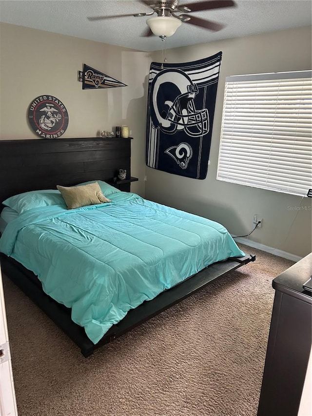 carpeted bedroom featuring ceiling fan and a textured ceiling