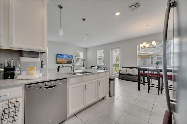 kitchen with decorative light fixtures, stainless steel dishwasher, sink, a chandelier, and white cabinets