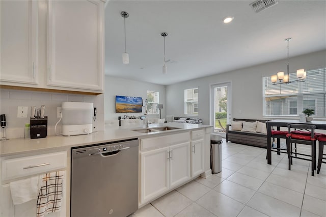 kitchen featuring light tile patterned floors, decorative light fixtures, a chandelier, sink, and stainless steel dishwasher