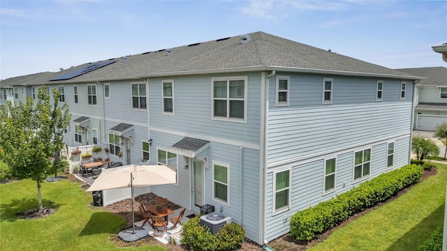 rear view of property featuring a lawn, a patio, and central air condition unit