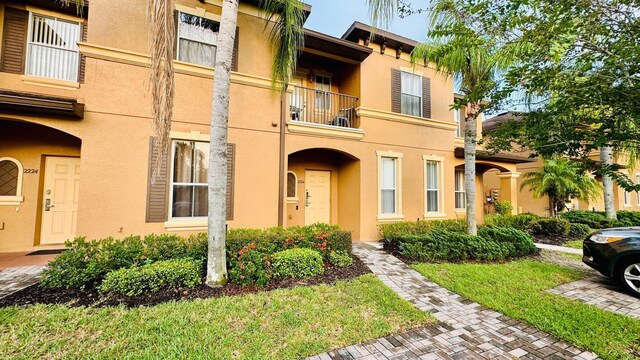 view of front of home with a front yard and a balcony