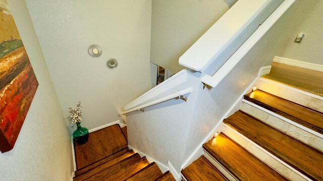 stairs with baseboards and wood finished floors